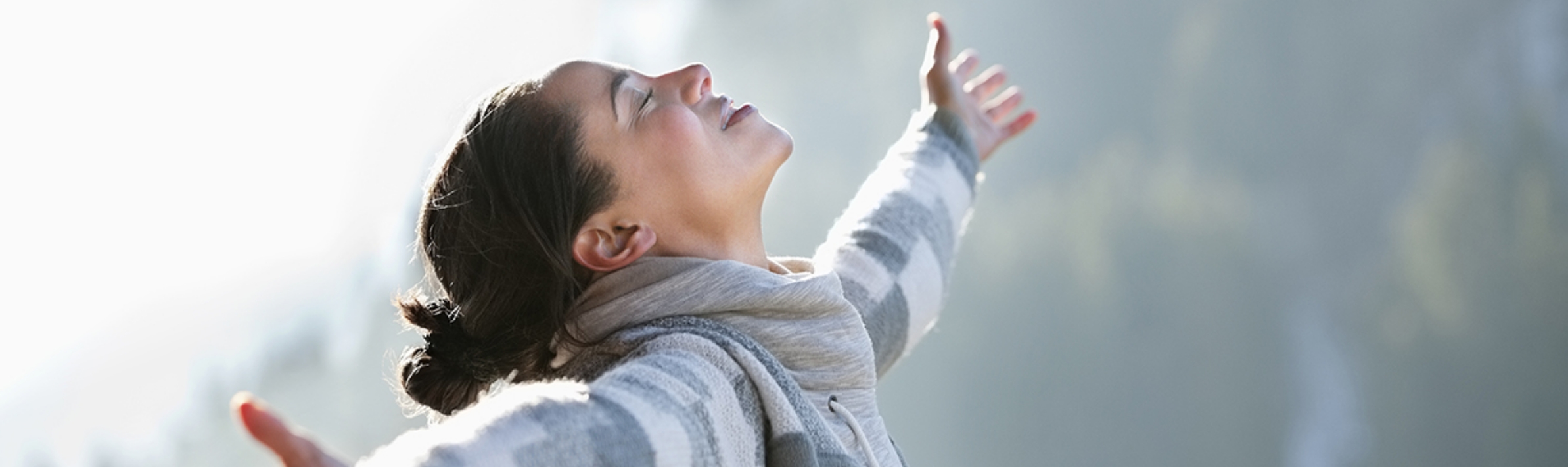 Woman smiling with arms outstretched.