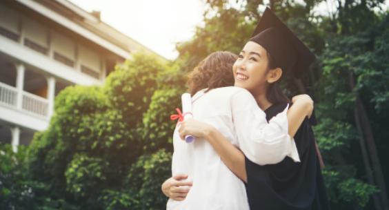 A newly gradated college student hugging a loved-one